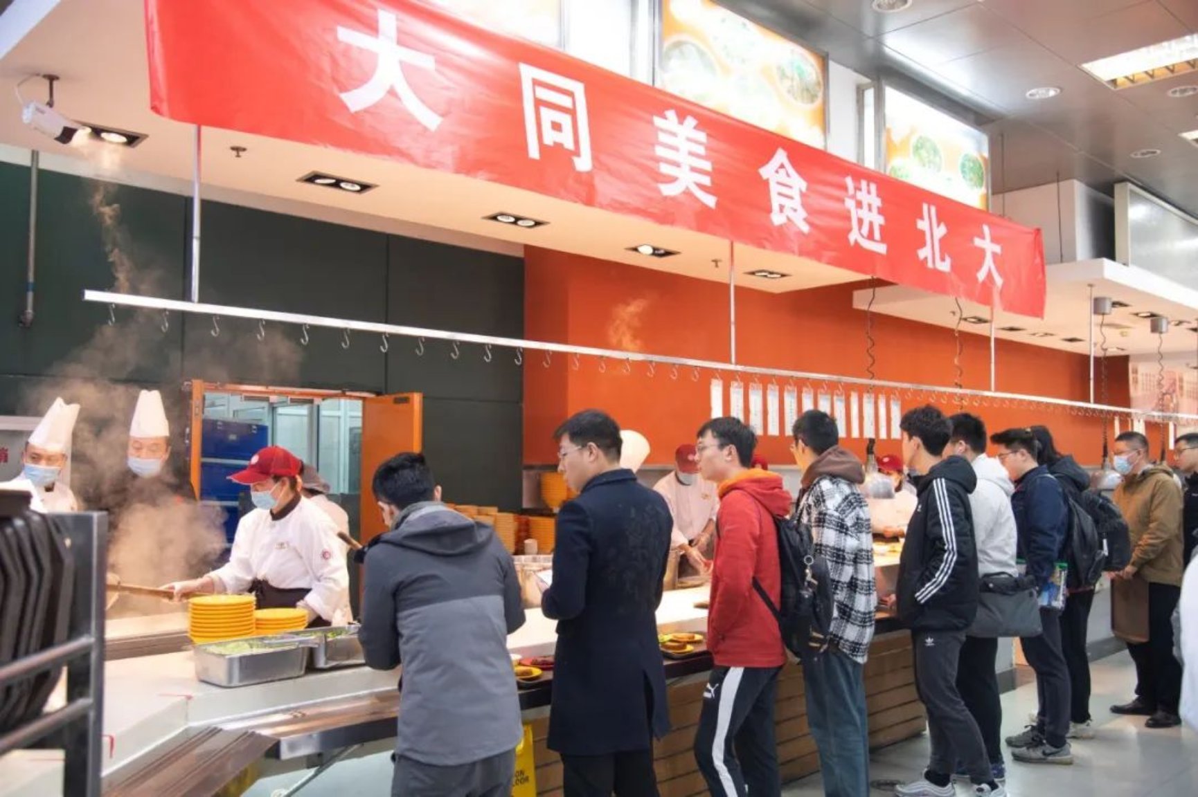 一群人站在柜台旁边
描述已自动生成